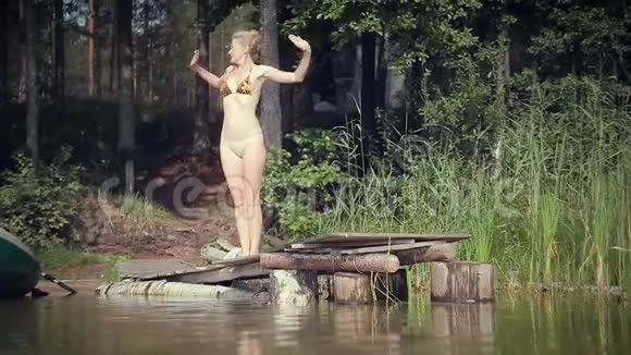 女人在湖上放松站在木墩边上视频的预览图