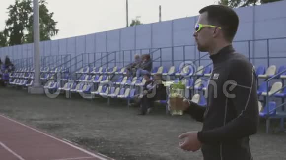 主题体育与健康年轻的白种人运动员从一个城市体育场的运动瓶里喝水视频的预览图