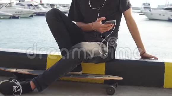 一个坐在长板上用手机的嬉皮士视频的预览图