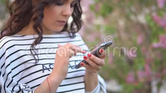 美丽的年轻女孩向你的朋友发送手机信息慢动作视频的预览图