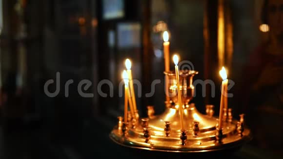 一个人把蜡烛放在宗教偶像面前的烛台上视频的预览图