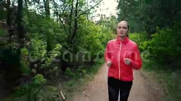 户外健身运动运动女人穿过树林她心情很好身材很好落叶视频的预览图
