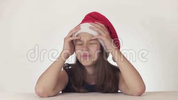 戴着圣诞老人帽子的美丽不幸少女表达了绝望情绪并开始在白色背景下哭泣视频的预览图