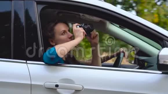 两个年轻的女人坐在车里玩得很开心其中一个在摄像机上拍照慢动作视频的预览图