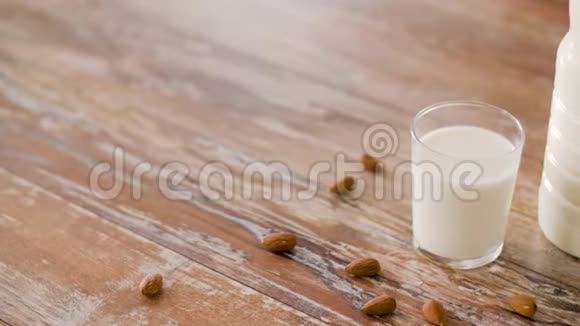 木制桌子上的无乳糖牛奶和杏仁视频的预览图