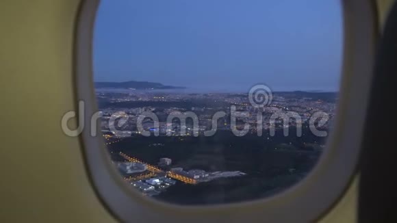 日落时分从落地飞机上俯瞰城市窗外视频的预览图