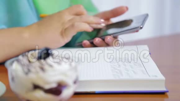 咖啡馆里的一个女人用电话和日记远程工作视频的预览图