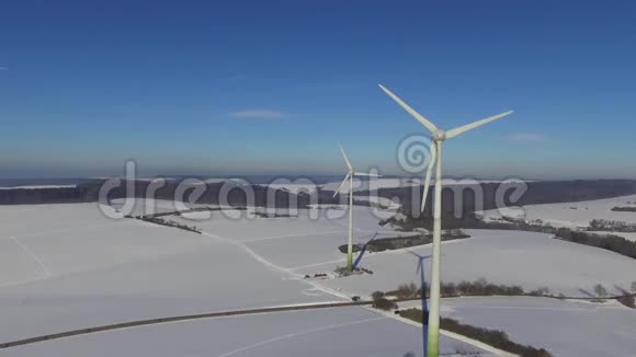 德国冰雪覆盖的冬季景色中的旋转风轮视频的预览图