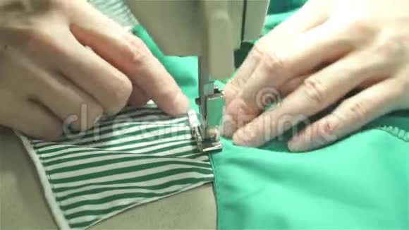 裁缝用蓝色布料在缝纫机上缝制衣服视频的预览图
