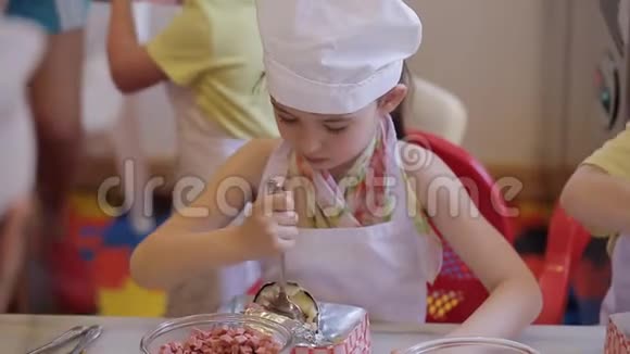 小女孩以厨师的形式在厨房里擀面团视频的预览图