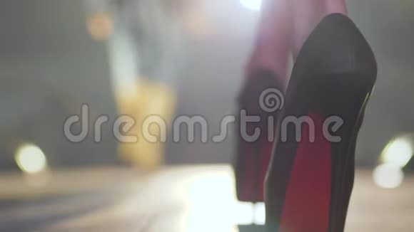 时尚周黑色高跟鞋的模特腿在模糊的背景下紧贴着烟雾视频的预览图