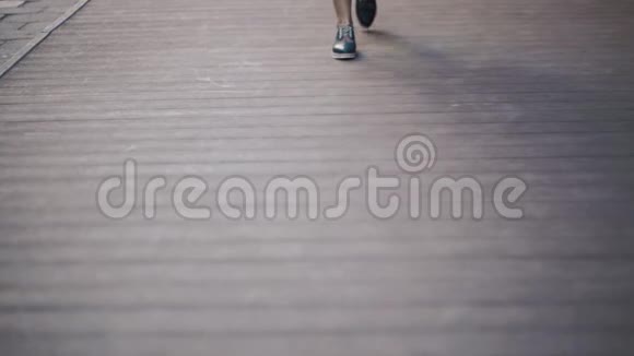 女孩正沿着街道走新蓝白鞋的特写视频的预览图