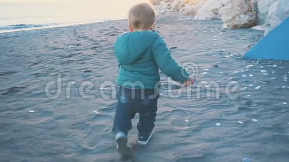 宝宝的生活方式那个男孩在日落时跑到海里假日概念慢动作视频的预览图