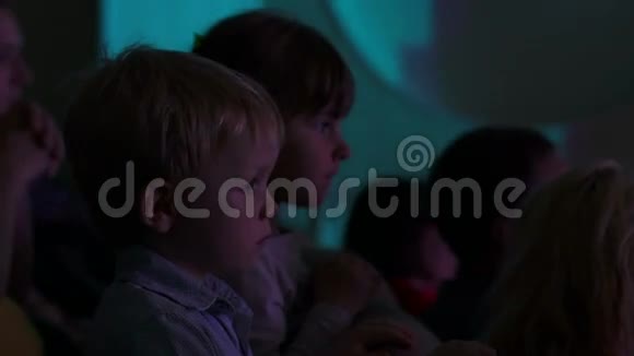 两个孩子在礼堂里看舞台视频的预览图