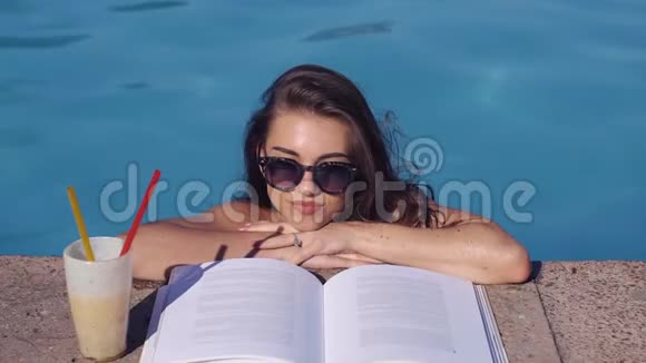美女看书走进游泳池顶部视图视频的预览图