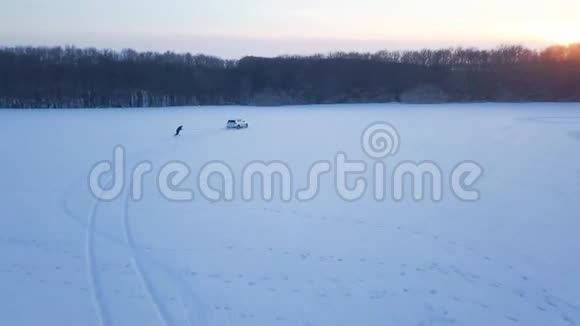 从高处到人的视野是在一个雪覆盖的田野上在一辆汽车后面的电缆上骑着一块滑雪板视频的预览图