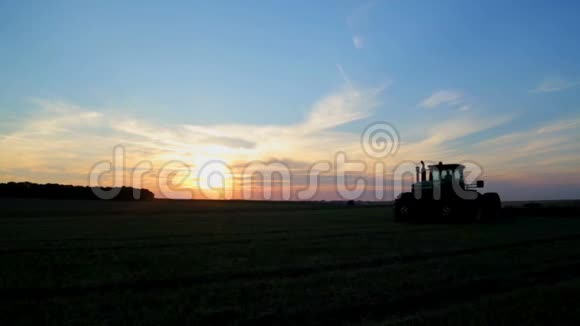 当天日落时拖拉机进行农业田间处理视频的预览图