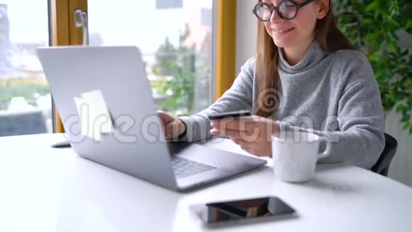 女人在家里用信用卡和笔记本电脑在线支付视频的预览图