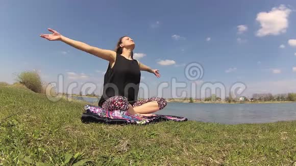 在湖边大自然中做瑜伽练习的女孩逐渐加速视频的预览图