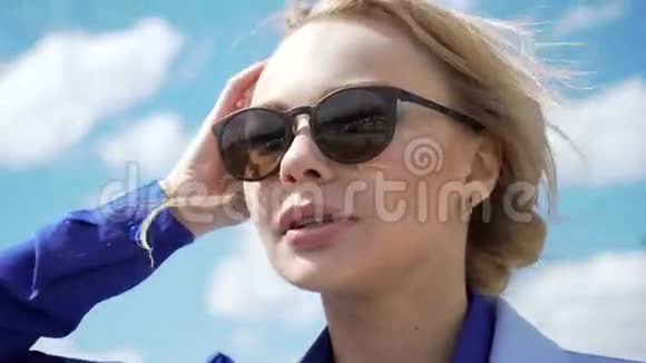一个漂亮的年轻金发女郎戴着飞行员太阳镜从阳光下背光视频的预览图