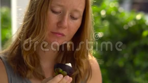 红发女人吃新鲜多汁的芒果视频的预览图