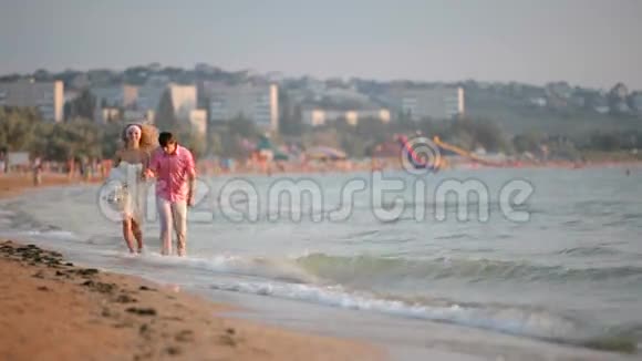 新婚夫妇在海滩上奔跑视频的预览图