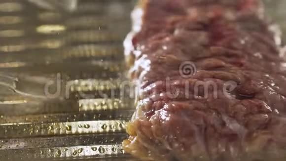 大块猪肉被烧烤炉上的火钳翻过来视频的预览图