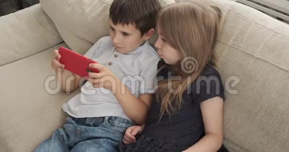 儿童躺在沙发上用手机视频的预览图