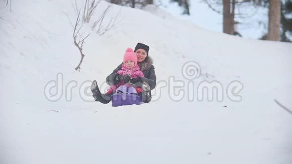 快乐的母亲在冬天的公园里和孩子一起雪橇视频的预览图