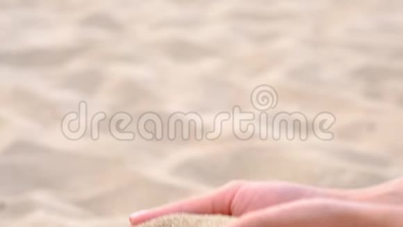 下面的动作结束未知的嬉戏的年轻女人扔了一把白沙时间就像沙子穿过视频的预览图