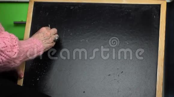 老妇人在黑板上写单词Health视频的预览图