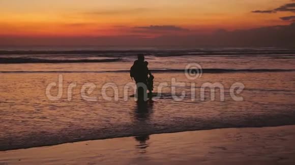 美丽的夕阳下幸福的家庭在海上漫步慢动作3840x2160视频的预览图