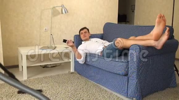 女人吸尘器男人从电视上遥控在沙发上放松女人把男人赶走挑选视频的预览图