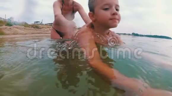妈妈教孩子在河里游泳视频的预览图