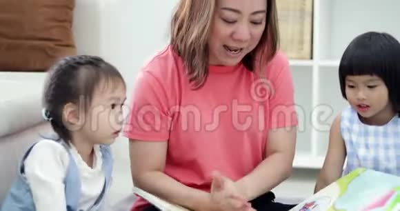 一位白种人的母亲和她的孩子在家里一起看卡通书上的滑稽漫画视频的预览图