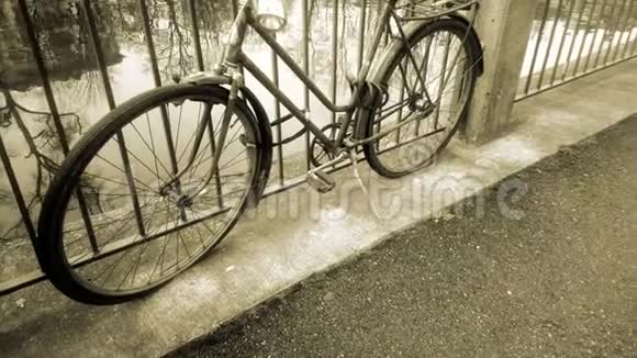 复古自行车站在河边系在栅栏上老式老式车辆视频的预览图