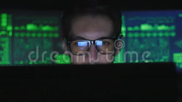 戴眼镜的黑客程序员正在电脑上工作在电脑安全中心喝着咖啡里面摆满了显示器视频的预览图
