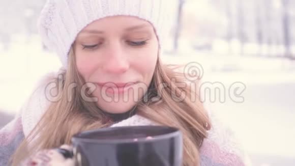 美丽的年轻女孩在公园外面喝热巧克力在外面享受气味很好保持温暖的舒适概念视频的预览图