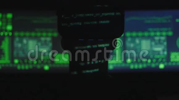 黑客程序员的剪影使用虚拟现实头盔进行编程而绿色代码字符则反映他的情况视频的预览图