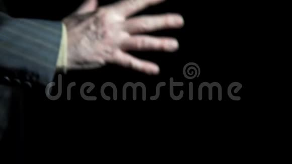 商人的手在黑色背景上展示无花果的手势视频的预览图