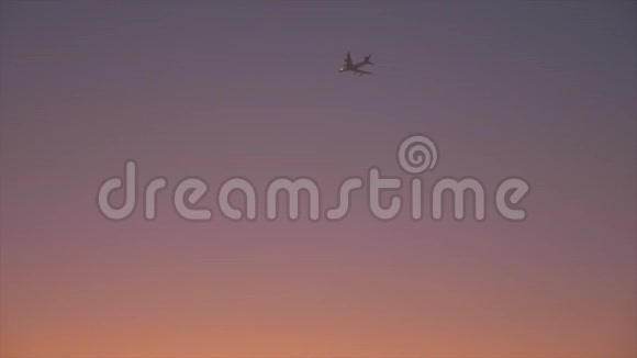 飞机在黄昏的天空中飞越沙漠傍晚沙漠中五彩缤纷的天空视频的预览图
