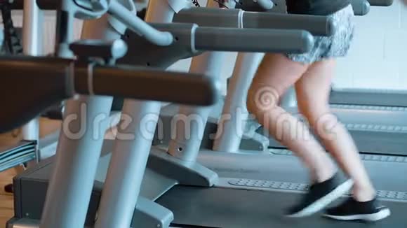 女孩在健身房跑步机上跑步视频的预览图
