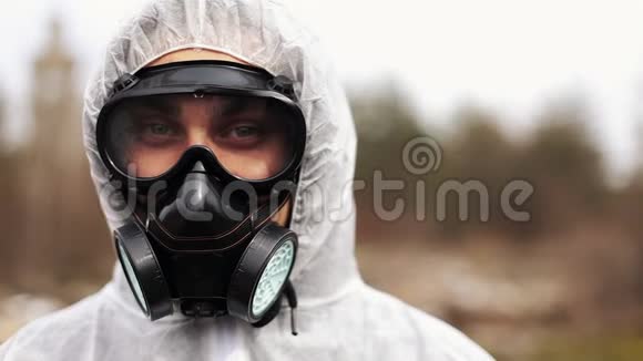 穿着生物危险服和防毒面具的人直视着摄像机视频的预览图
