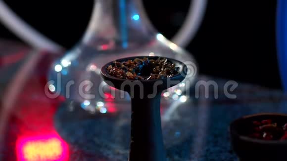 一碗水烟在黑暗中用钳子和烟草特写视频的预览图