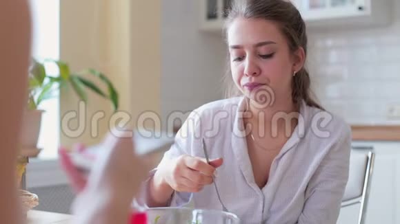 两个女孩坐在厨房的桌子上聊天视频的预览图