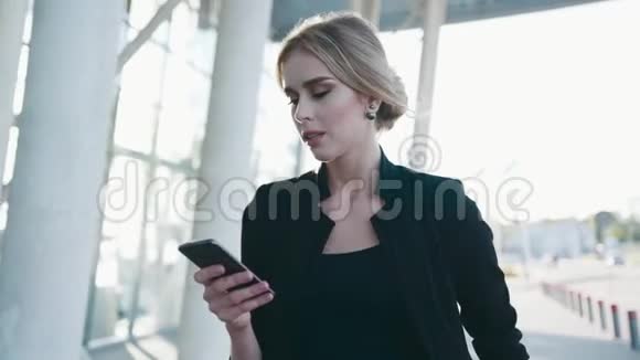 一位留着正式发型的欧洲女商人匆匆走过机场候机楼给她发短信视频的预览图