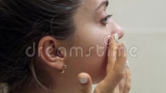 美丽的女人用护肤乳液来洗脸用女性美容产品护理皮肤视频的预览图