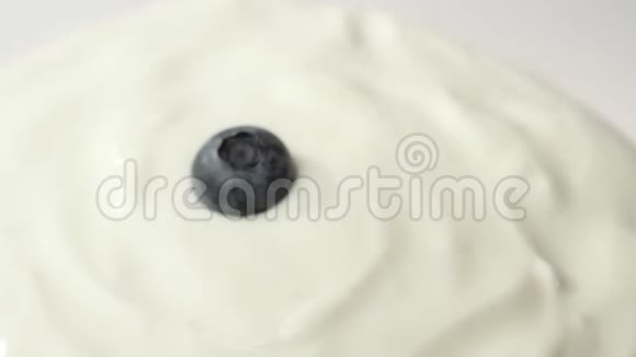 新鲜健康食品蓝莓在白色背景下掉入酸奶中鲜果洒在鲜奶油里有机浆果视频的预览图