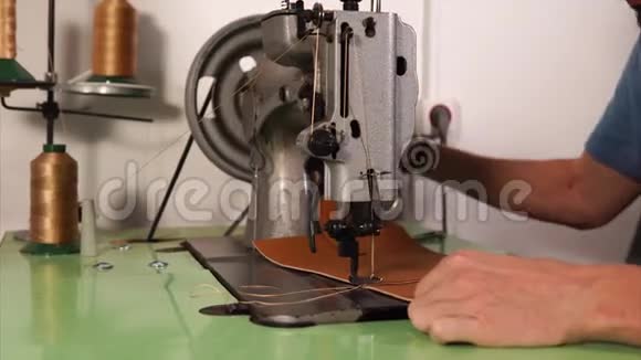 男人用皮革做缝纫机的手视频的预览图