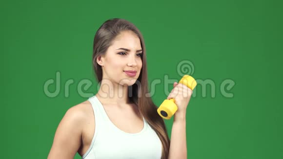 快乐美丽的女运动员拿着哑铃和一瓶微笑的水视频的预览图